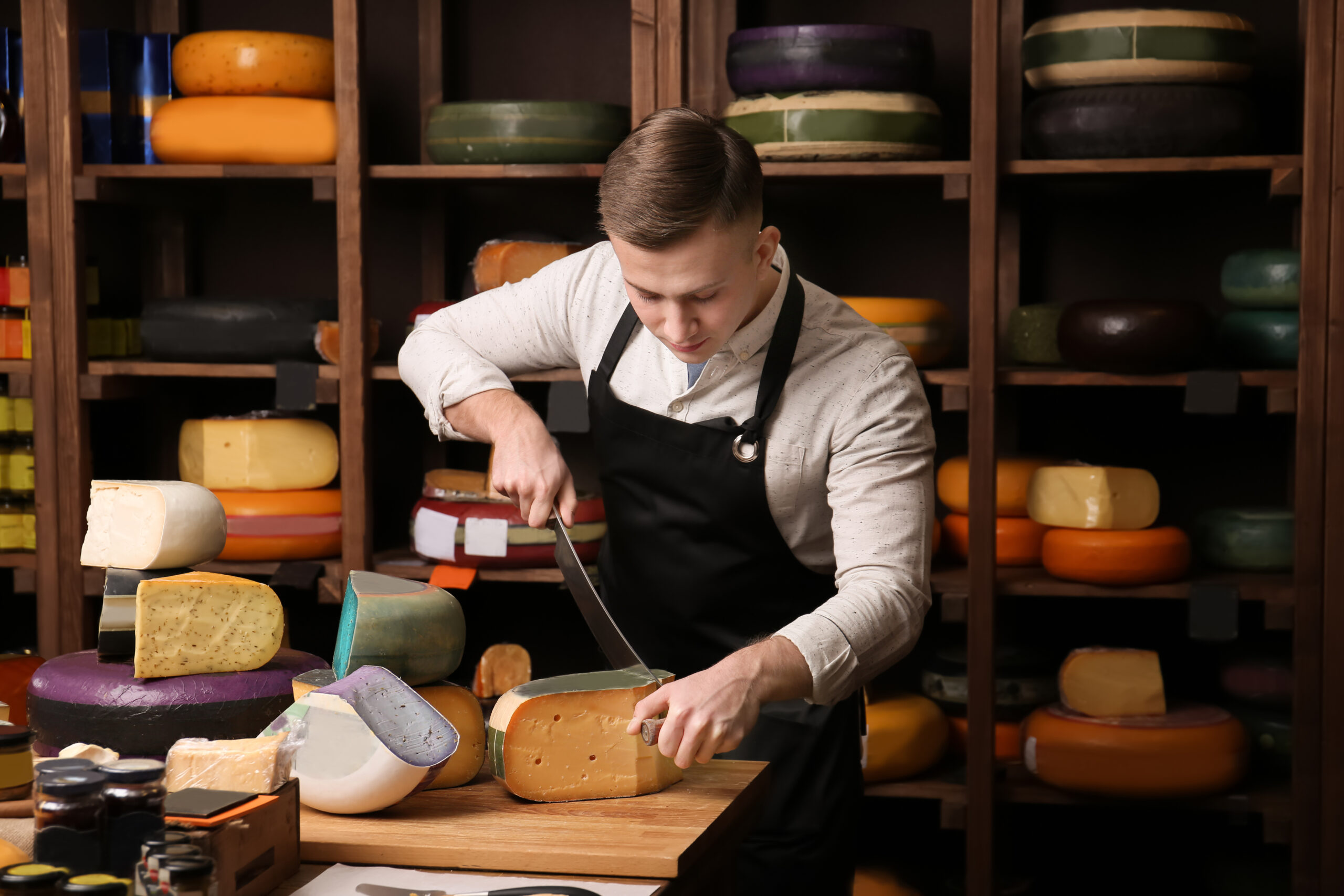 man cutting cheese block
